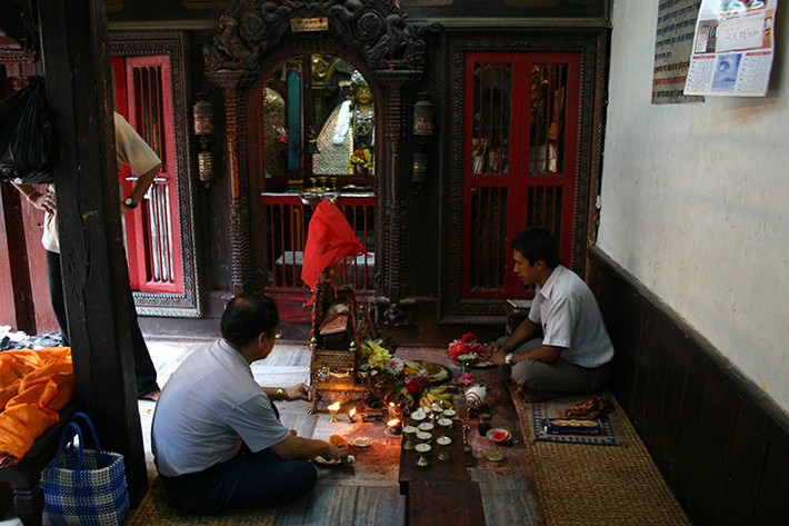 Prajpramit pustaka pj: Main priest, Cakra Raj Bajracharya (Vajrcrya), Min Bahadur Shakya (patron, jajmn), and the book on its throne-like seat.